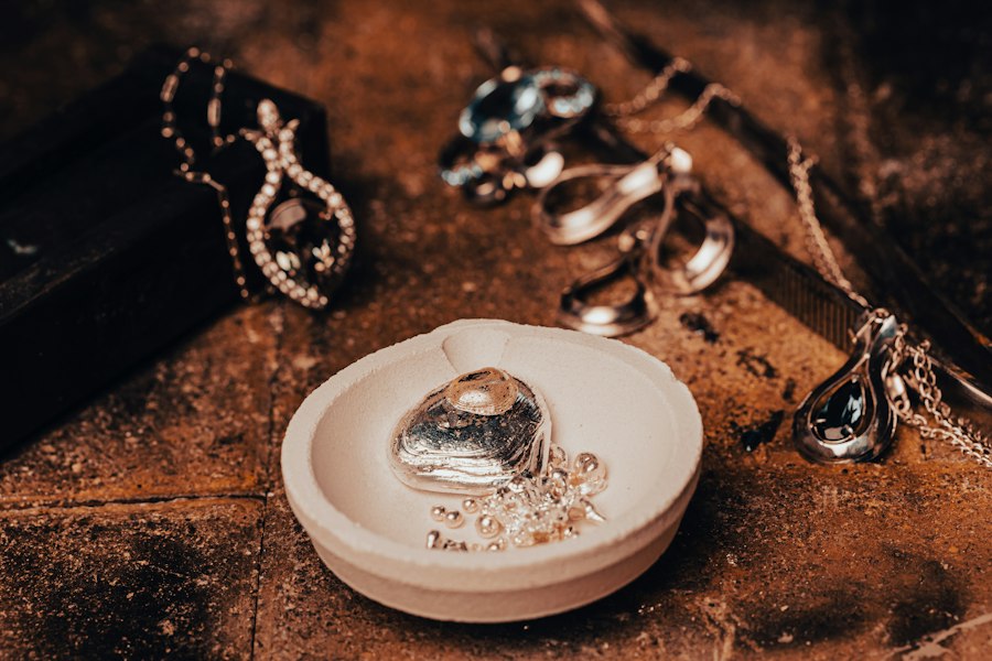 Piese de bijuterie așezate pe un bol de ceramică, pe o masă de lemn